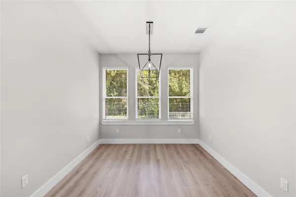 an empty room with window and chandelier