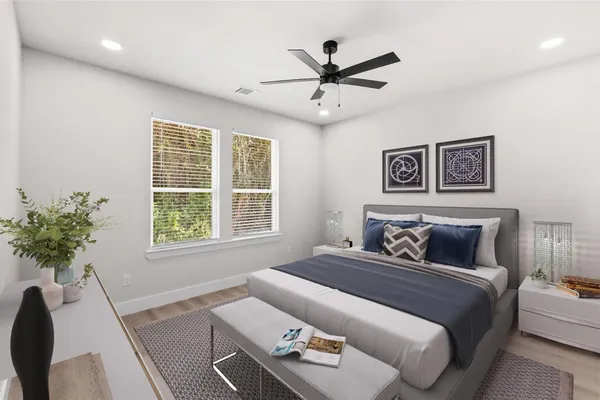 a bedroom with a large bed and a potted plant