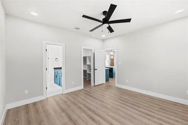 wooden floor in an empty room with a ceiling fan