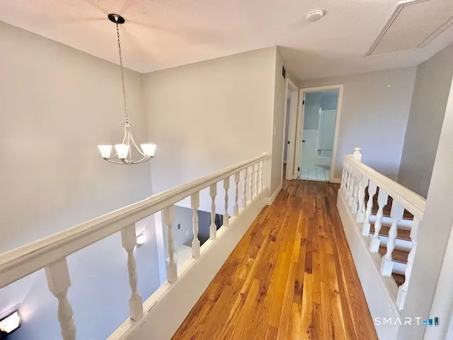 a view of a hallway with wooden floor and staircase