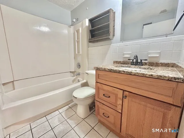 a bathroom with a granite countertop toilet sink and mirror