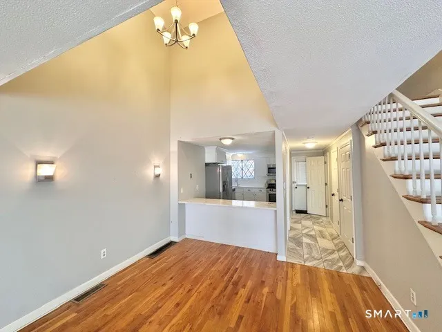 a view of a big room with wooden floor and windows