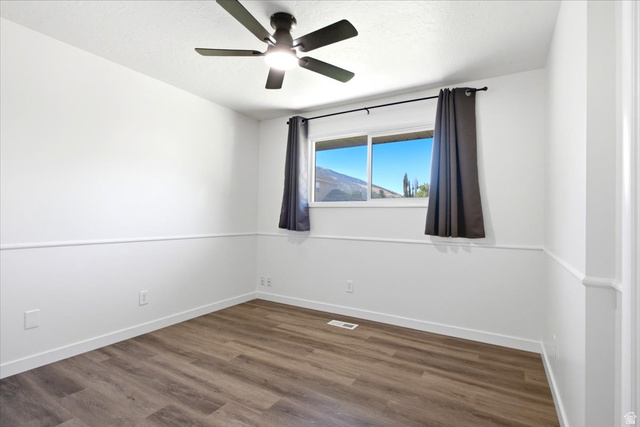 1676 East 11245 South Sandy, UT 84092 - Photo 16 of 34 Neutral white walls with chair rail molding and wood-finish flooring