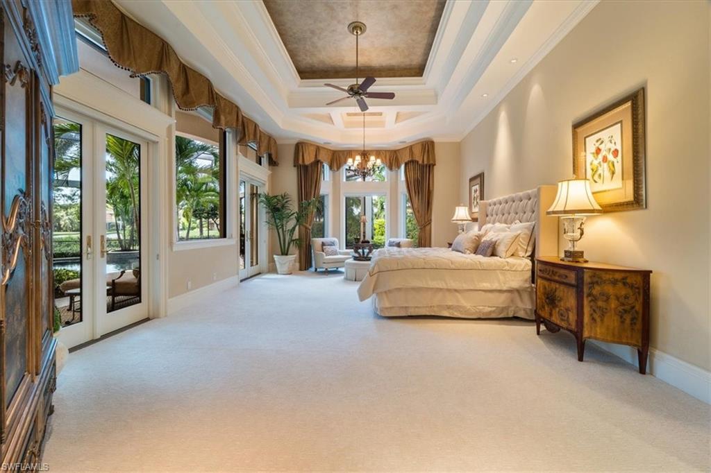 15299 Corsini Lane Naples, FL 34110 - Photo 15 of 40 a spacious bedroom with a bed and glass door