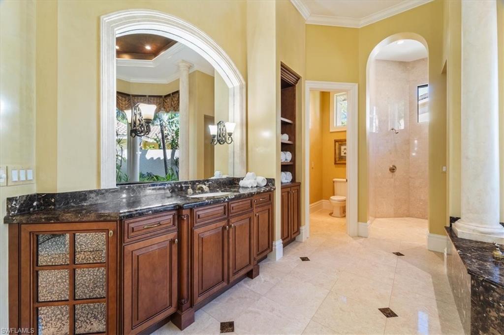 15299 Corsini Lane Naples, FL 34110 - Photo 21 of 40 a spacious bathroom with a granite countertop sink and a mirror