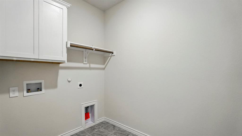 4191 Waldron Trail Forney, TX 75126 - Photo 7 of 20 Dedicated laundry area featuring white shaker-style cabinetry with crown molding, a built-in hanging rod, and durable tile flooring