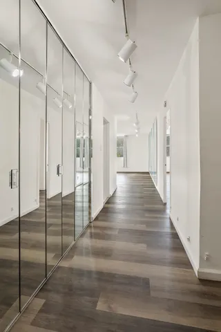an empty room with wooden floor and entryway