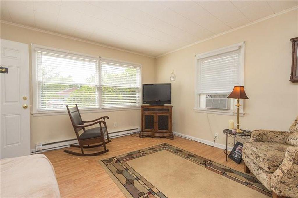2902 20th St Extension, Unit 1 Beaver Falls, PA 15010 - Photo 2 of 7 a living room with furniture a flat screen tv and a floor to ceiling window