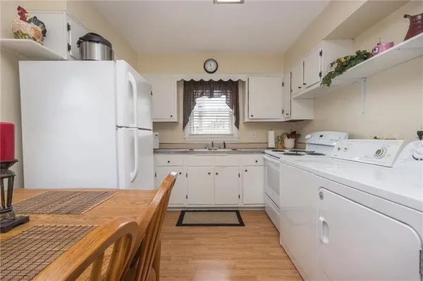 a kitchen with white cabinets and sink