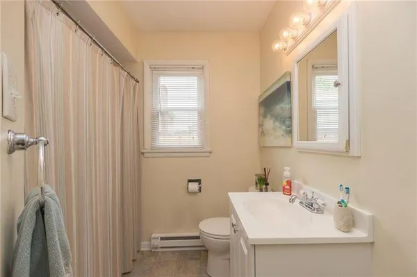 a bathroom with a sink a toilet and shower curtain