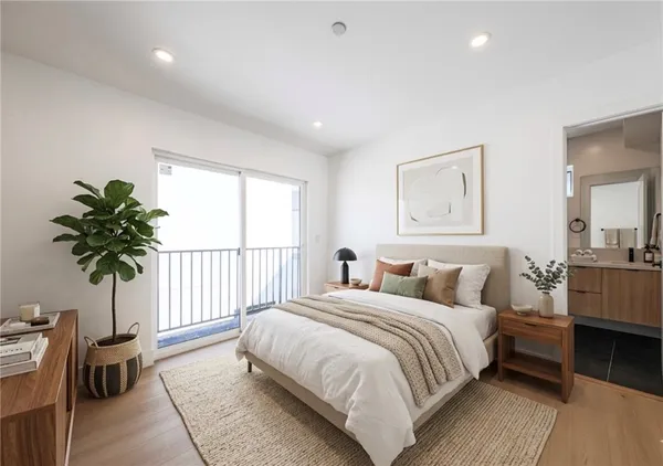 a bedroom with a large bed and a potted plant