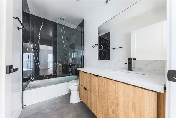 a bathroom with a double vanity sink toilet mirror and bathtub