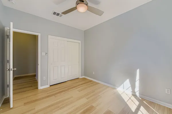 a bedroom with a bed and a chandelier fan