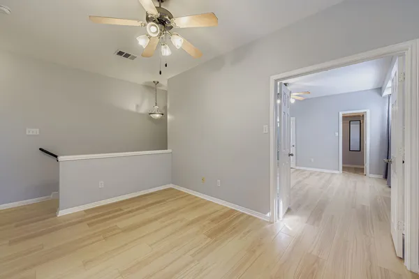 a view of a room with wooden floor and chandelier fan