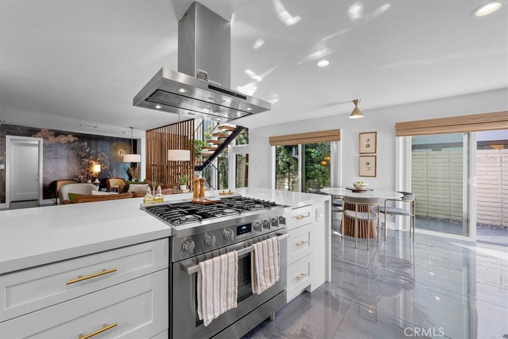 35 Geneva Walk Long Beach, CA 90803 - Photo 8 of 52 a kitchen with stainless steel appliances granite countertop a stove a sink dishwasher a dining table and chairs with wooden floor