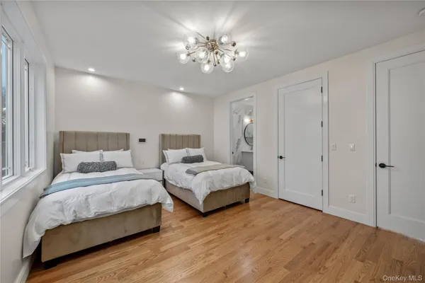 a spacious bedroom with a bed and a chandelier
