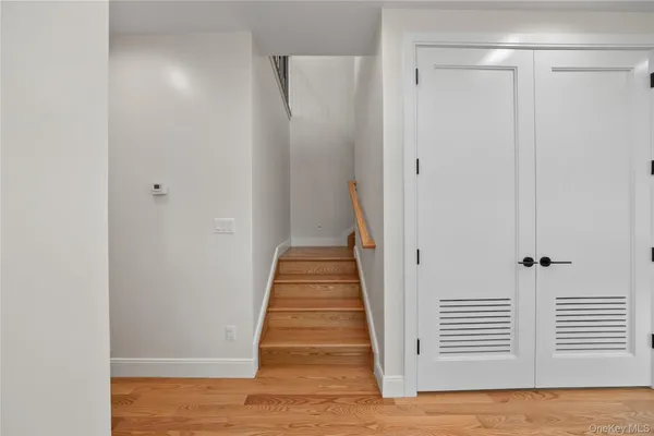 a view of a hallway with wooden floor and a white door