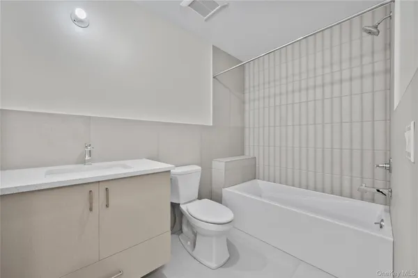 a bathroom with a toilet sink vanity tub and shower