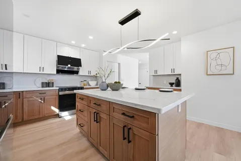 a kitchen with stainless steel appliances a stove refrigerator sink microwave and cabinets