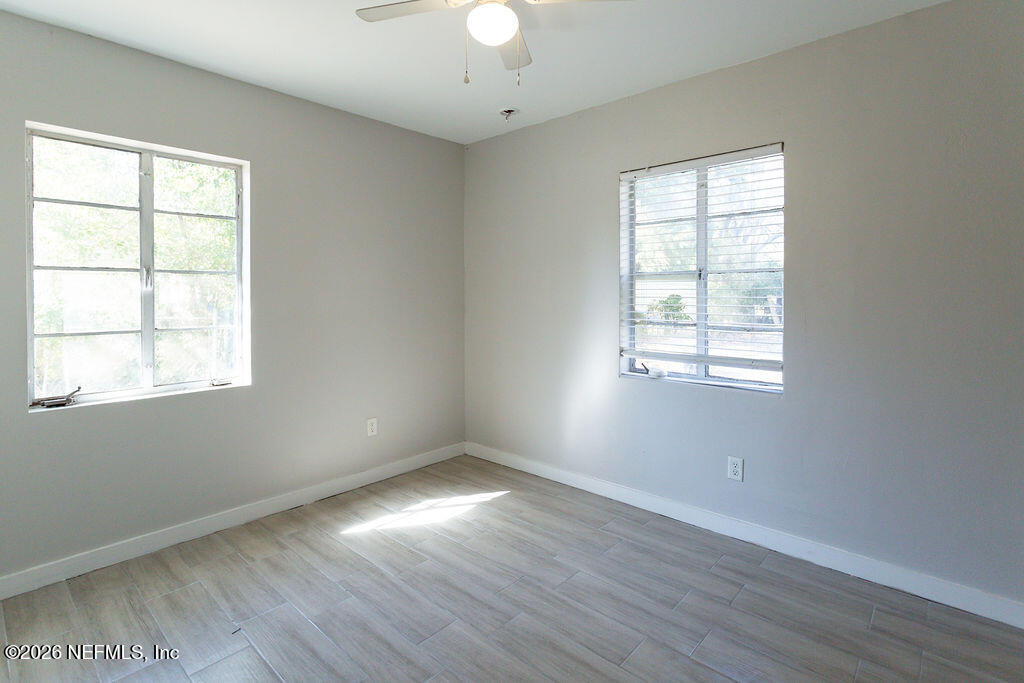 2533 Orchard Street Jacksonville, FL 32254 - Photo 9 of 13 an empty room with wooden floor chandelier and windows