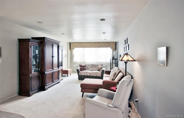 a living room with furniture a large window and a walk in closet