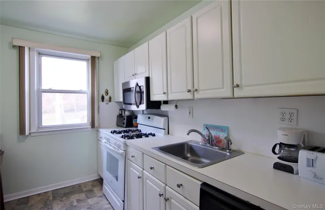 a kitchen with stainless steel appliances granite countertop a sink a stove and cabinets