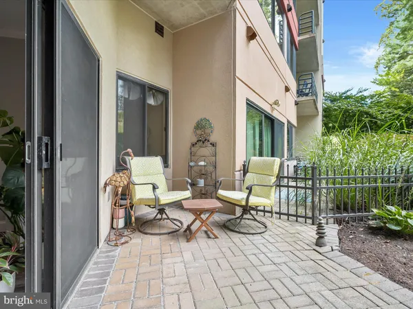 a view of a patio with couple of chairs and a fountain
