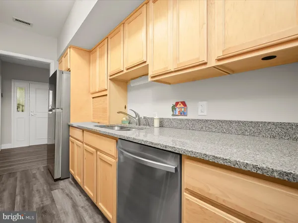 a kitchen with stainless steel appliances granite countertop a sink and dishwasher with wooden floor