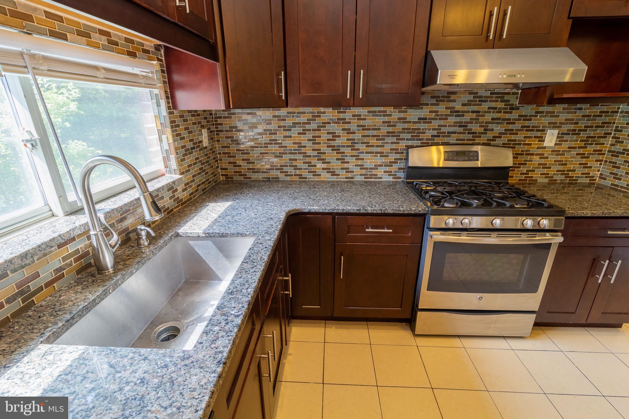1545 Shoemaker Road Abington, PA 19001 - Photo 17 of 32 a kitchen with granite countertop a stove top oven cabinetry a sink and a counter