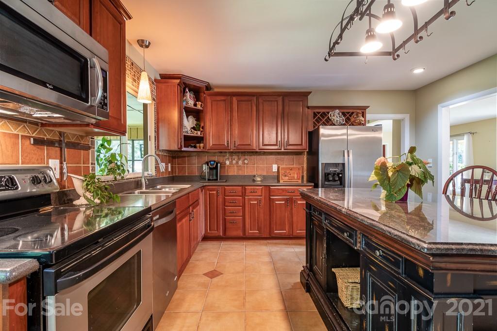 4401 Rounding Run Road Charlotte, NC 28277 - Photo 14 of 31 a kitchen with stainless steel appliances granite countertop a stove a sink and a microwave