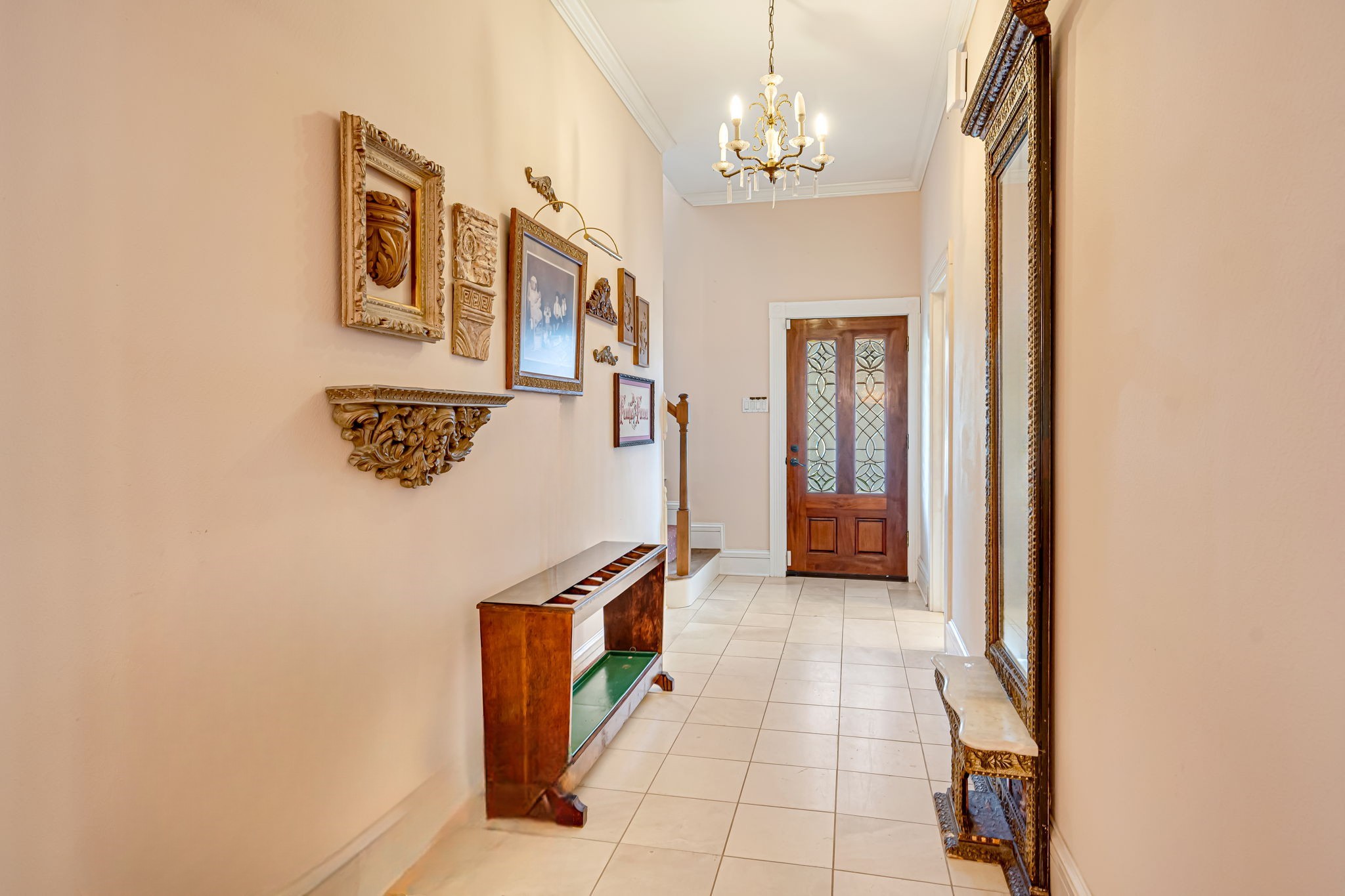 4028 Crosby Cedar Bayou Road Baytown, TX 77521 - Photo 9 of 35 View from the dining room down the rear hall toward the back door, with stairs to the second level and utility room access; high ceilings, chandelier, and tile flooring.