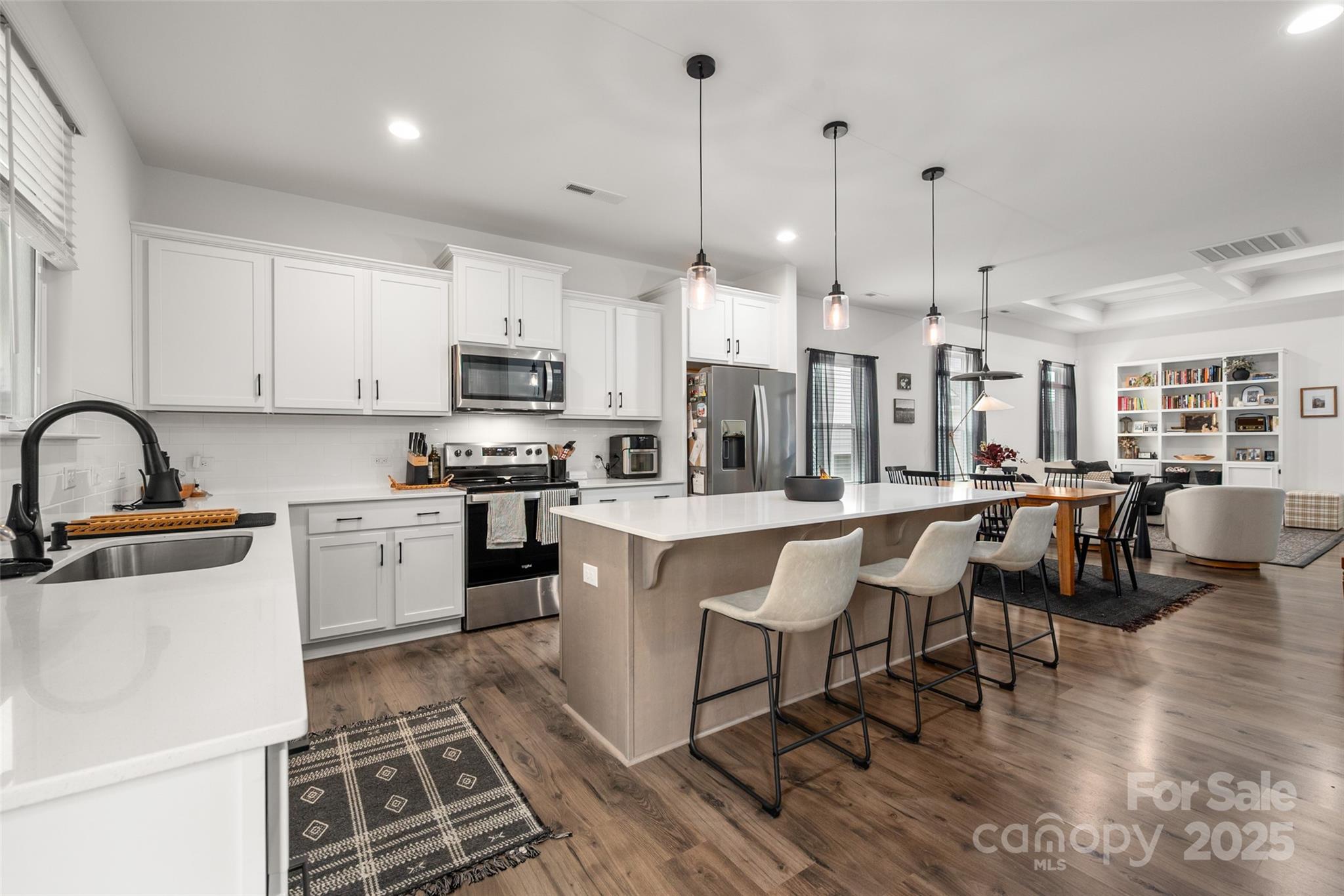 1024 Scotch Meadows Loop, Unit 32 Monroe, NC 28110 - Photo 8 of 19 a kitchen with stainless steel appliances granite countertop a stove a sink dishwasher a refrigerator and a dining table with wooden floor