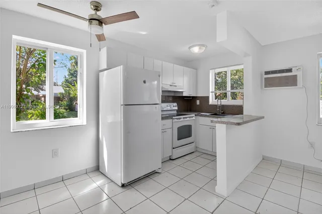 a kitchen with white cabinets and white appliances
