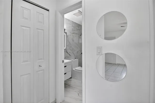 a bathroom with a mirror a sink and a toilet