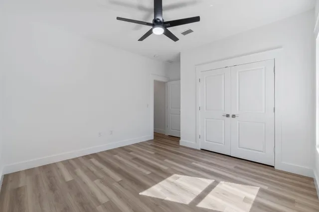 a view of empty room with wooden floor