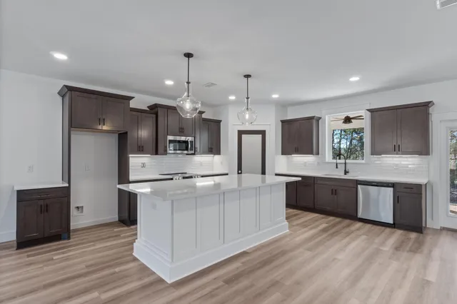 a large kitchen with stainless steel appliances kitchen island granite countertop a large counter top and sink