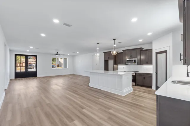 a view of kitchen with kitchen island and stainless steel appliances