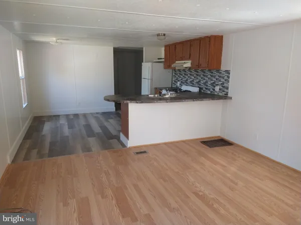 a kitchen with wooden floor and cabinets