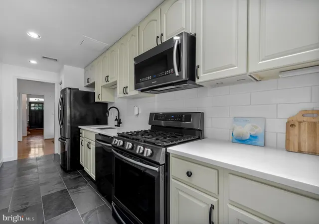 a kitchen with stainless steel appliances granite countertop a stove a microwave and a refrigerator