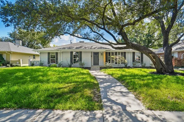 a front view of a house with yard and green space