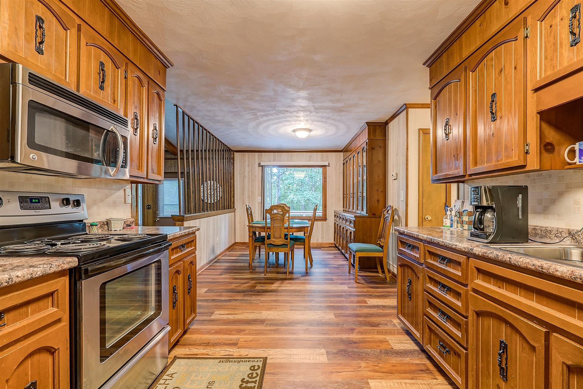 5960 Goodview Road Goodview, VA 24095 - Photo 11 of 38 a kitchen with stainless steel appliances granite countertop a stove top oven a sink a dining table and chairs with wooden floor