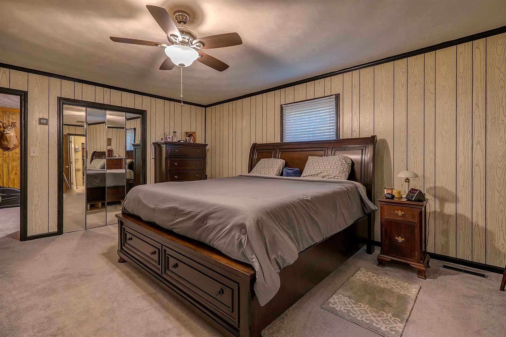 5960 Goodview Road Goodview, VA 24095 - Photo 13 of 38 a spacious bedroom with a bed and a chandelier