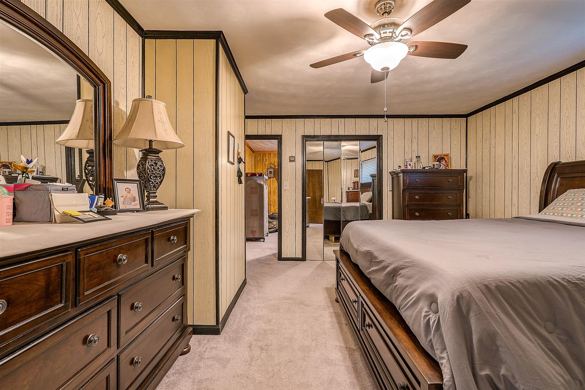 5960 Goodview Road Goodview, VA 24095 - Photo 14 of 38 a spacious bedroom with a large bed and a chandelier