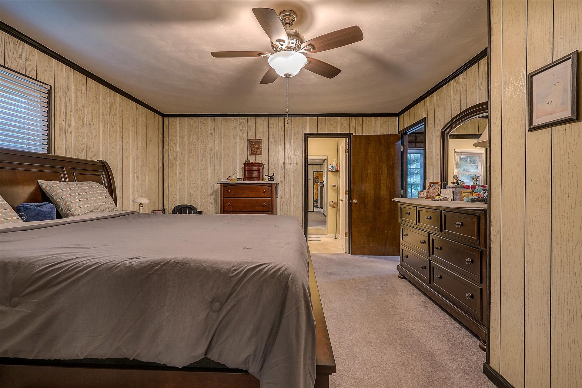 5960 Goodview Road Goodview, VA 24095 - Photo 16 of 38 a bedroom with a bed and a chandelier