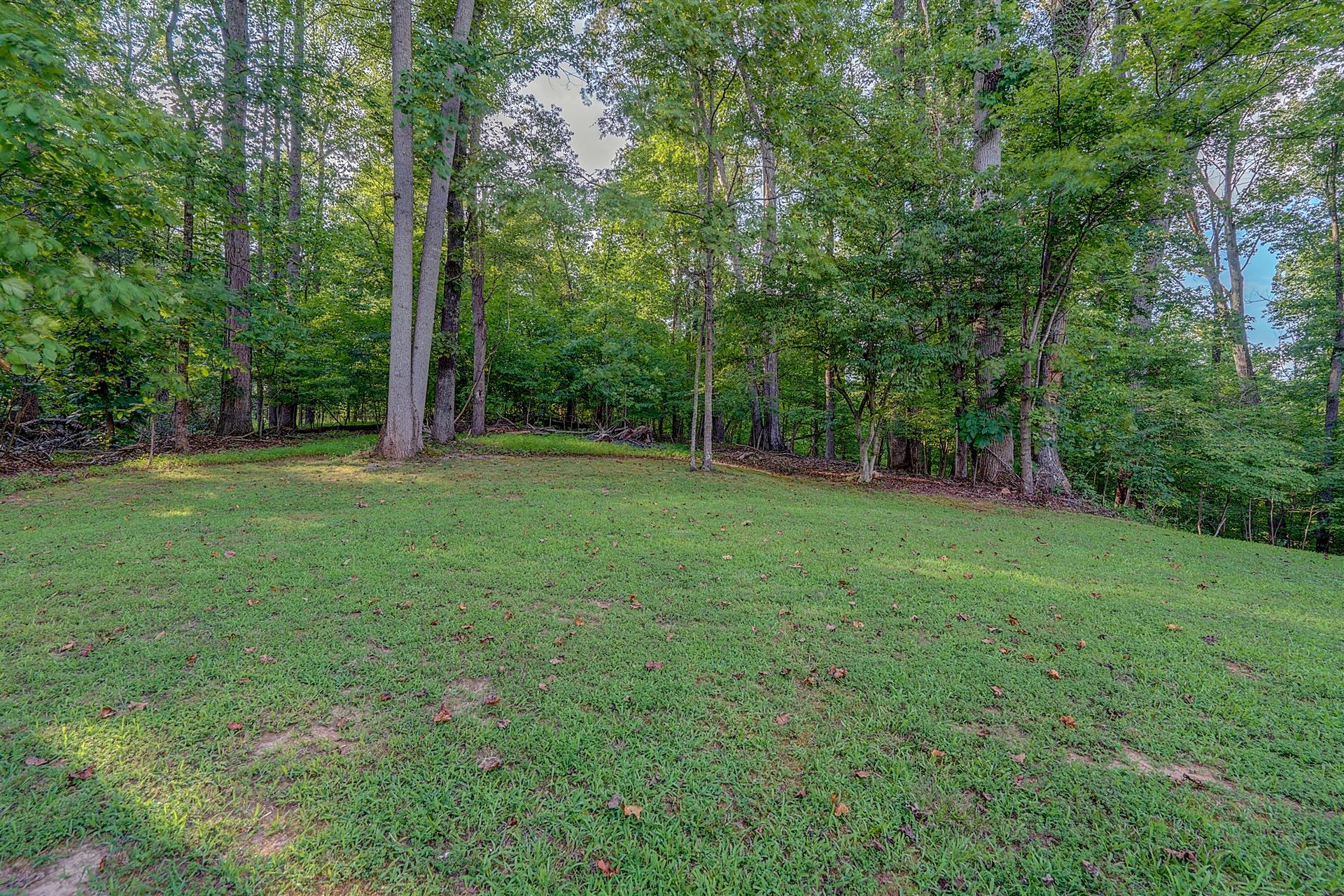 5960 Goodview Road Goodview, VA 24095 - Photo 5 of 38 a backyard of a house with lots of plants and large trees