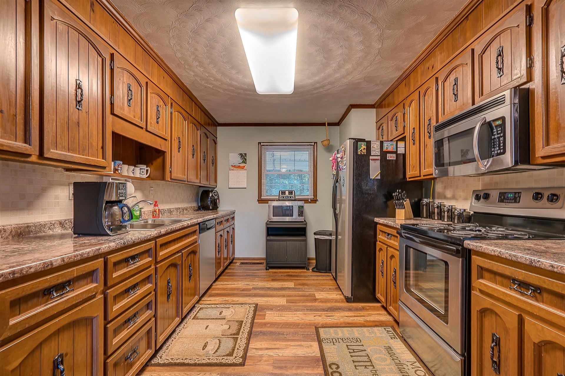 5960 Goodview Road Goodview, VA 24095 - Photo 10 of 38 a large kitchen with stainless steel appliances granite countertop a stove top oven a sink dishwasher a dining table and chairs with wooden floor