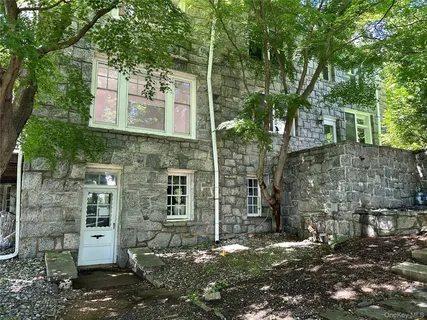 a view of a brick house with a large tree