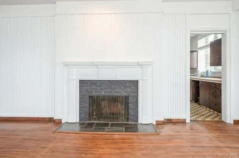 a view of a livingroom with wooden floor a fireplace and window