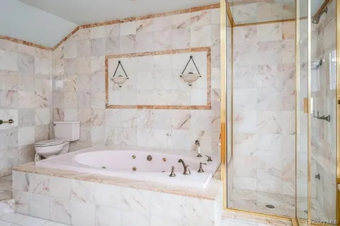 a bathroom with a granite countertop tub sink shower and mirror