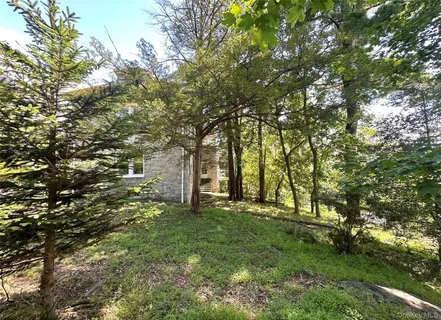 a large yard with lots of green space and house in the back